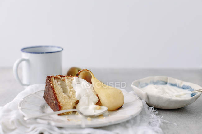 Slice of pear sponge cake with mug of tea — Stock Photo