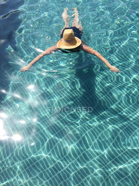 Mujer con sombrero de paja en la piscina - foto de stock
