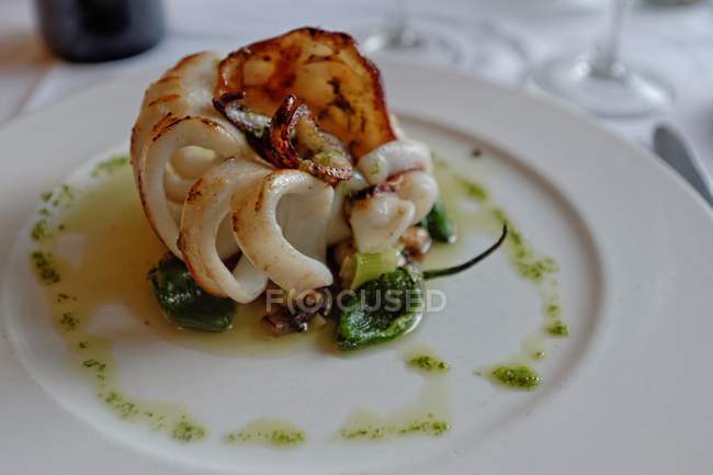 Вкусный жареный кальмар с соусом на белой тарелке — стоковое фото