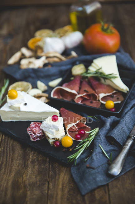 Fette di prosciutto iberico e tapas di formaggio sul tavolo di legno — Foto stock