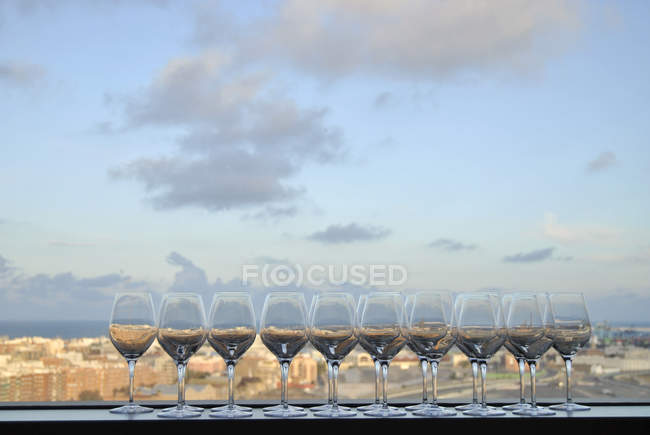Ten glasses of wine on a window ledge with city view in the background, Valencia, Spain — Stock Photo
