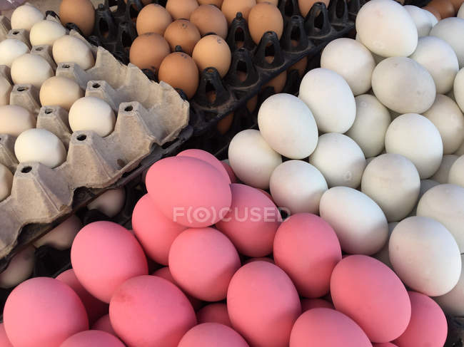 Rosafarbene, weiße und braune Eier auf Bauernmarkt — Stockfoto