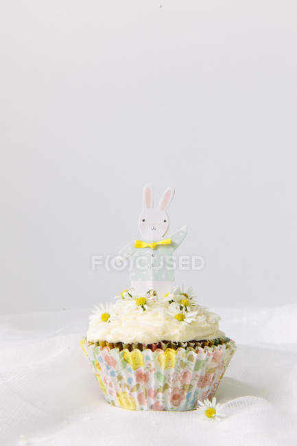 Cupcake decorated with daisies and an easter bunny — Stock Photo