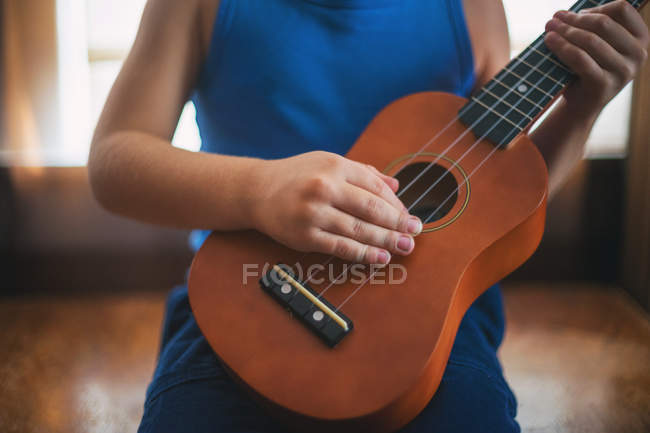 Image recadrée de fille jouer un ukulélé — Photo de stock