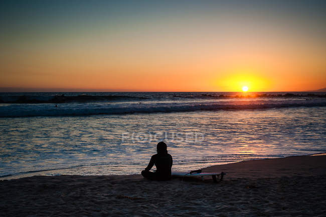 EUA, Califórnia, Venice Beach, Silhueta de mulher olhando para o pôr do sol — Fotografia de Stock