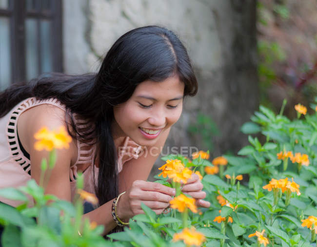 Молода жінка збирає квіти в саду — стокове фото
