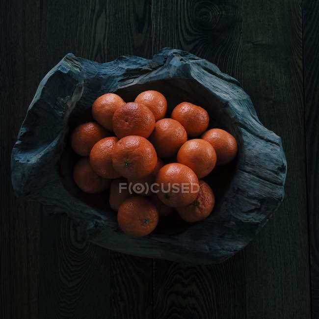 Bowl of fresh oranges on wooden surface — Stock Photo