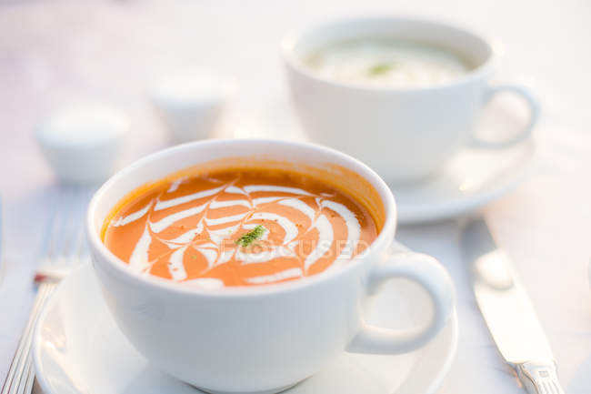 Cups of mushroom soup and tomato bisque — Stock Photo