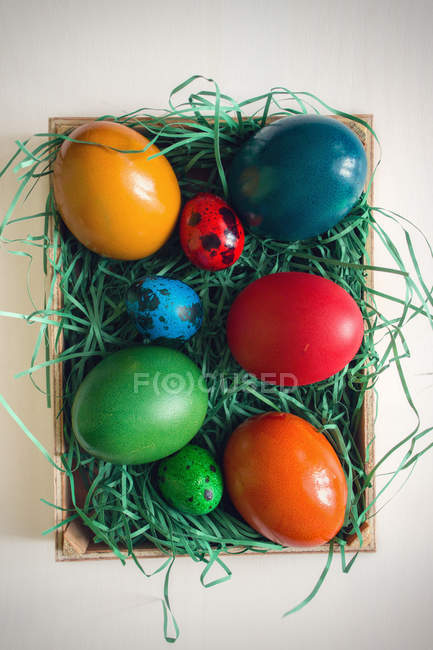 Vista elevada de la cesta con coloridos huevos de Pascua - foto de stock