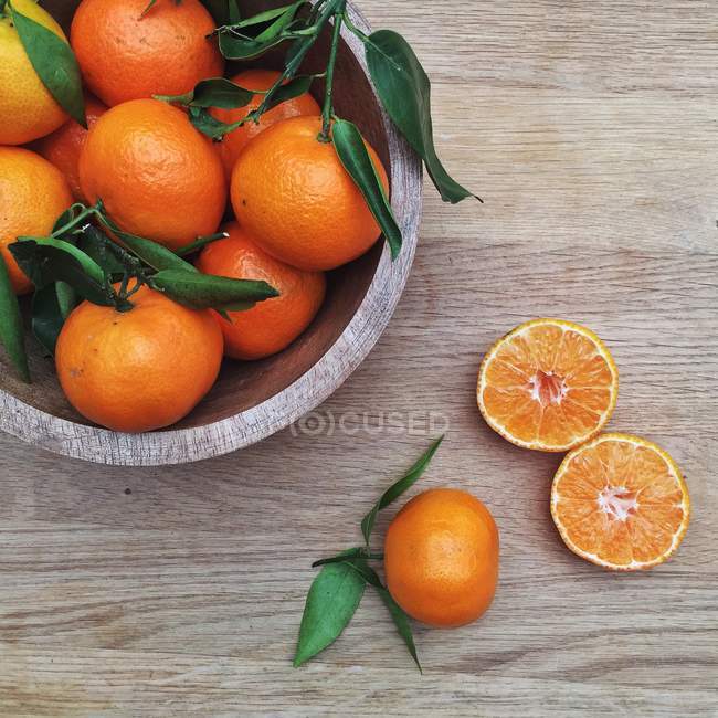 Tigela de tangerinas na mesa de madeira, vista superior — Fotografia de Stock