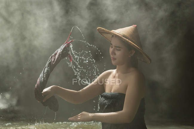 Primer plano retrato de hermosa mujer lavando ropa en el río, Tailandia - foto de stock