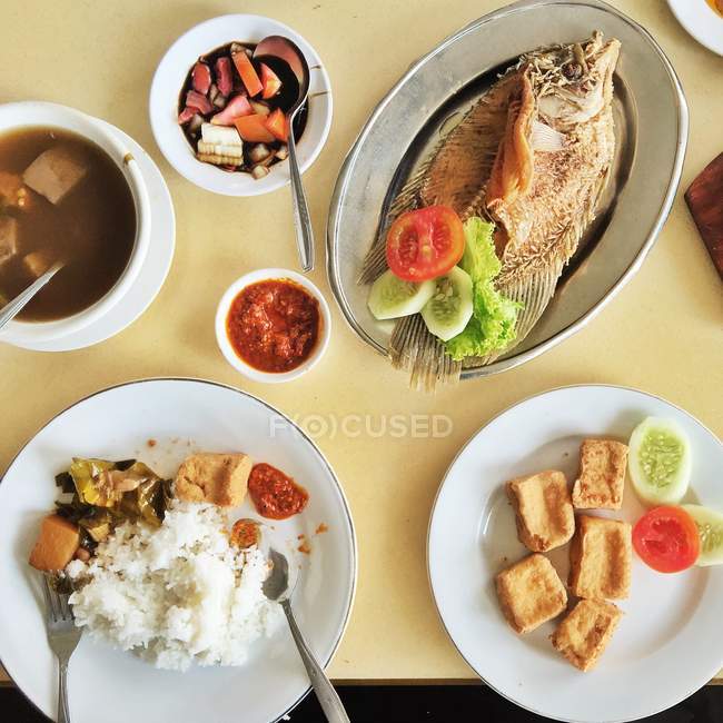 Vista superior de pescado, tofu, sopa agria y arroz sobre la mesa - foto de stock