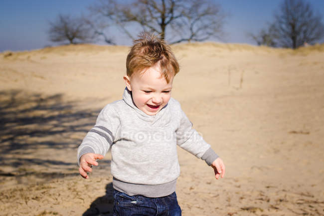 Счастливый маленький мальчик играет на открытом воздухе — стоковое фото