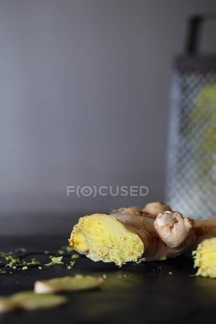 Closeup view of ginger root lying on table against blurred background — Stock Photo