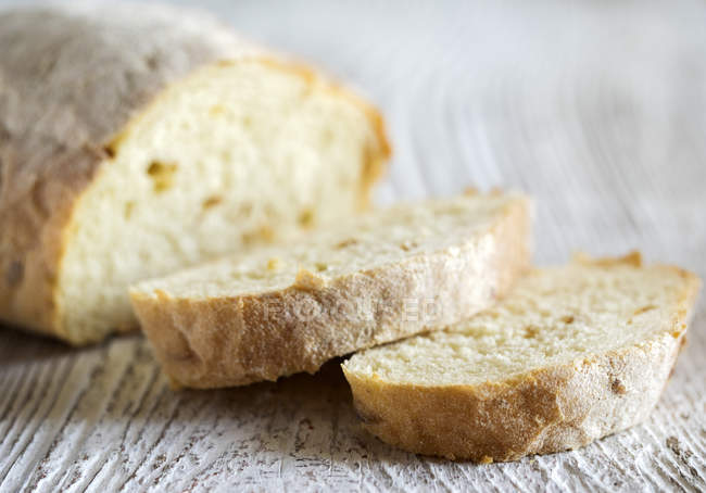 Loaf of wholemeal bread and slices of bread — Stock Photo