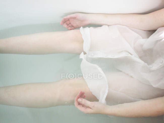 Imagen recortada de chica pálida acostada en la bañera - foto de stock