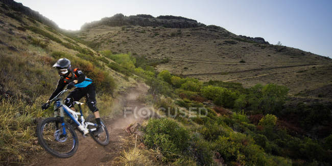 USA, Colorado, Jefferson County, Golden, Mountain biker che scende lasciando nuvole di polvere — Foto stock
