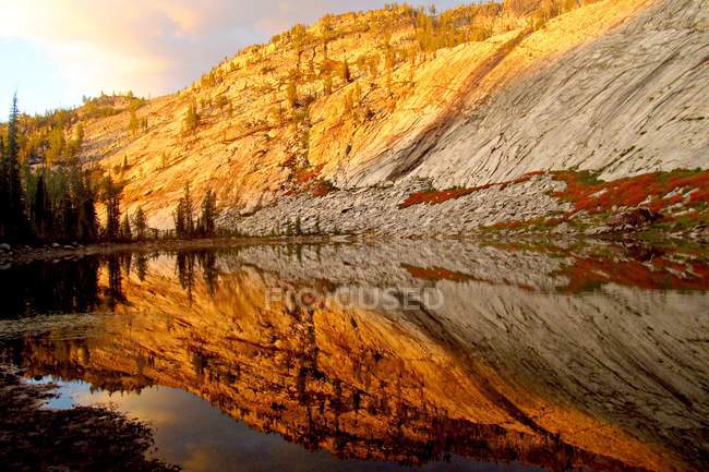 Morning light and rock reflecting in lake, Bitterroot Mountains, USA — Stock Photo