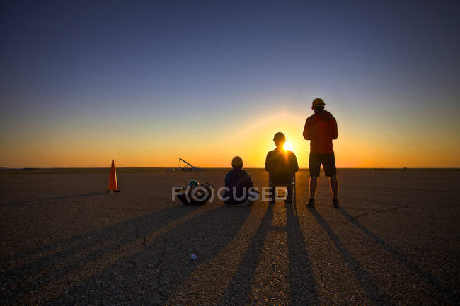 Estados Unidos, Nuevo México, Silueta de personas mirando el amanecer - foto de stock