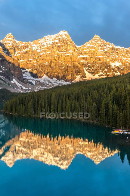 Canada, Banff National Park, Canadian Rockies, Mountains reflecting in calm lake at sunrise — Stock Photo