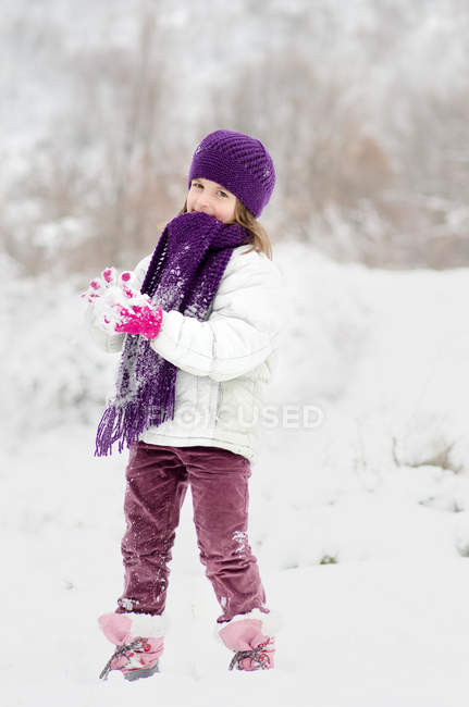 Mädchen in warmer Kleidung spielt im Schnee — Stockfoto