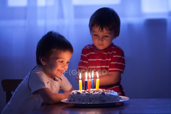 Two caucasian boys with birthday cake at table — Stock Photo