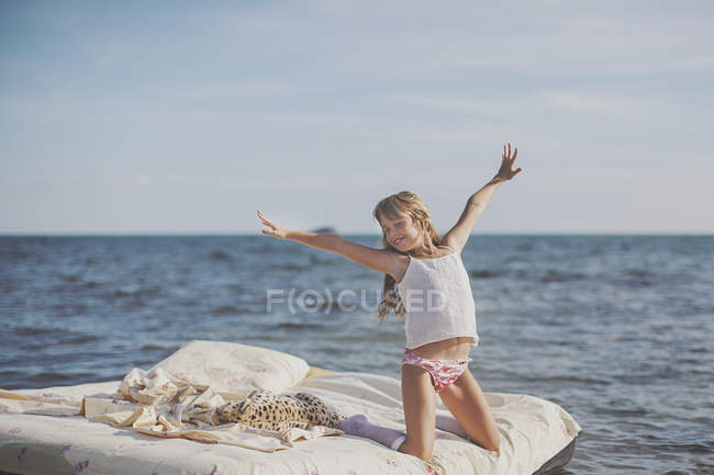 Молода блондинка на ліжку в морі — стокове фото