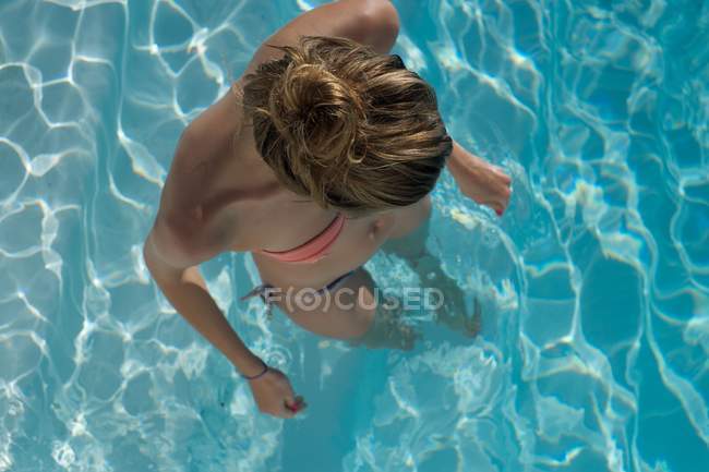 Jeune femme blonde debout dans une piscine — Photo de stock