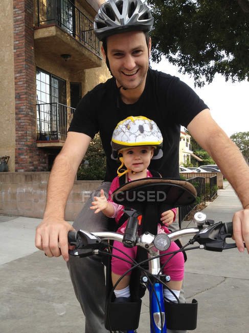 Щасливий батько їде на велосипеді з маленькою дочкою малюка — стокове фото