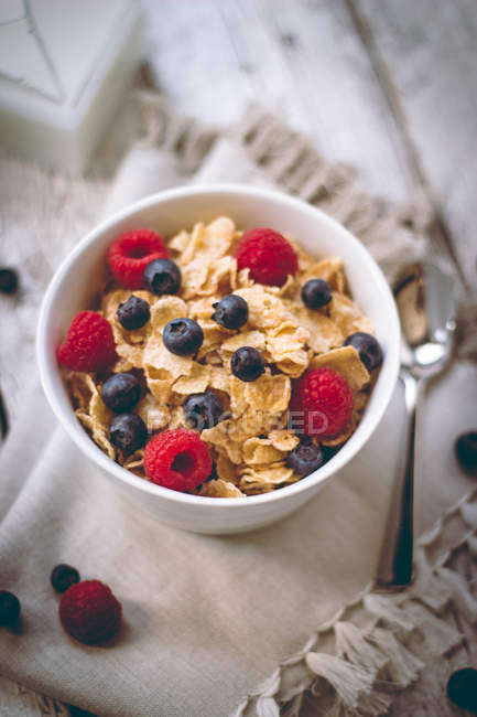 Close-up of Cornflakes with blueberries and raspberries in bowl — Stock Photo