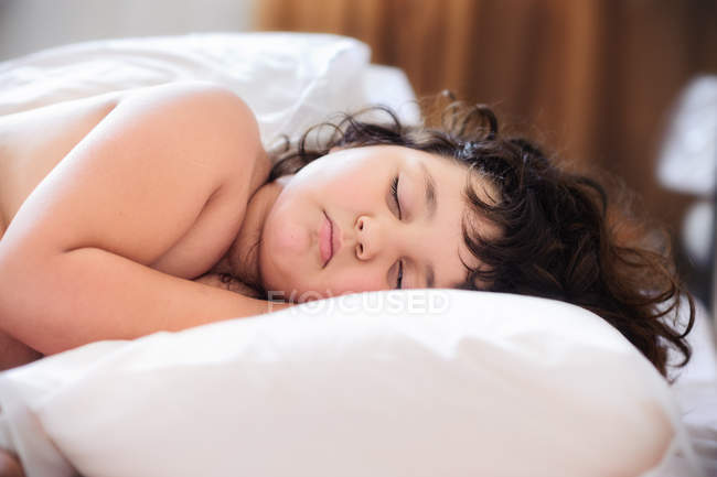 Torse nu petite fille dormir sur grand oreiller — Photo de stock
