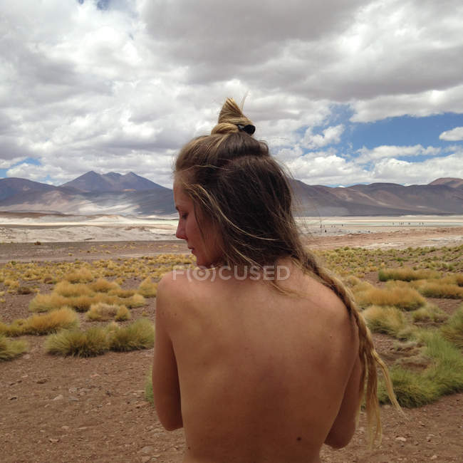 Chile, Porträt einer nackten Frau, die in der Wüste über die Schulter schaut — Stockfoto