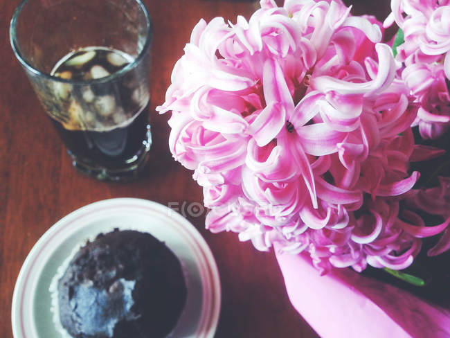 Vue surélevée du muffin et du café pour le petit déjeuner à côté de la jacinthe fleur — Photo de stock