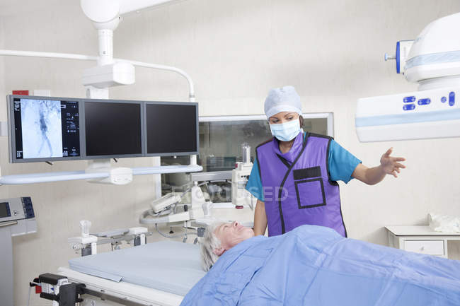 Médecin femme adulte avec patient dans la chambre avec équipement médical — Photo de stock