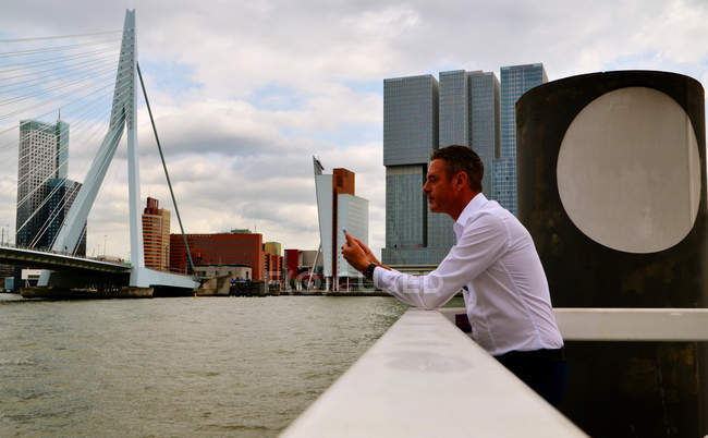 Niederlande, Rotterdam, Geschäftsmann mit Smartphone am Wasser — Stockfoto