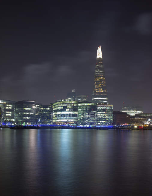 Shard skyscraper illuminated at night and Thames river in foreground, London, UK — Stock Photo