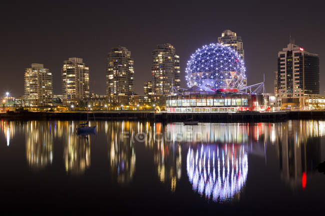 Canada, British Columbia, Vancouver, False Creek, Illuminated skyscrapers reflecting in river — Stock Photo