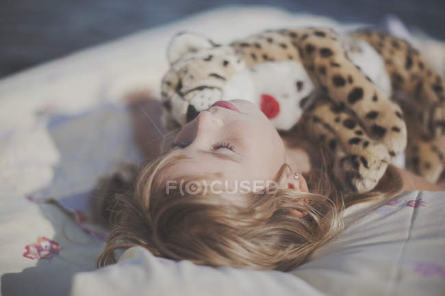 Niño rubio joven durmiendo en la cama de aire en el mar - foto de stock
