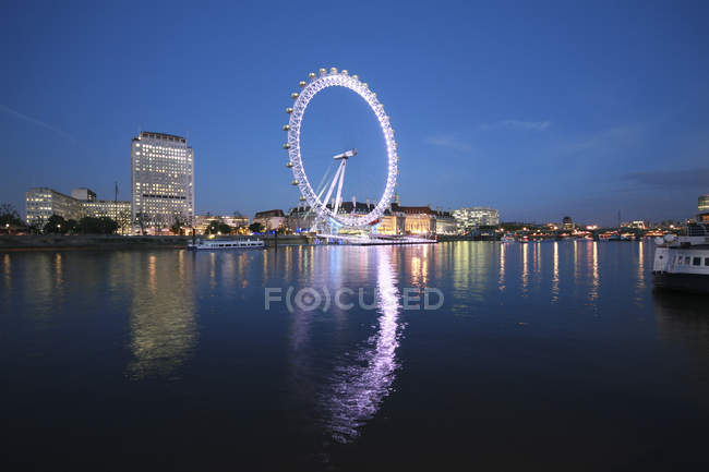Árboles iluminados con London Eye en el fondo por la noche, Reino Unido, Inglaterra, Londres - foto de stock