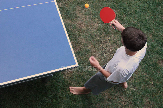Elevated view of boy playing table tennis outdoors — Stock Photo