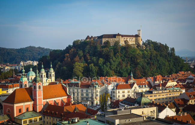 Castillo en colina boscosa y paisaje urbano circundante, Liubliana, Eslovenia - foto de stock