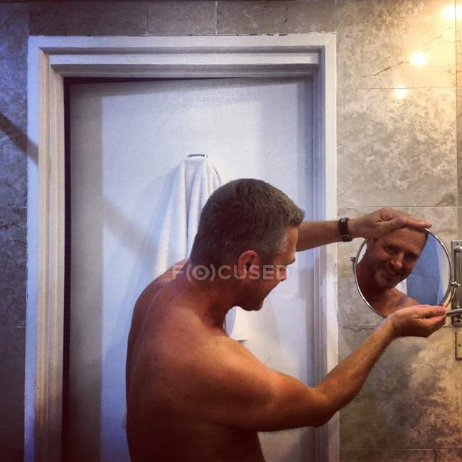Shirtless sorrindo Homem olhando espelho no banheiro — Fotografia de Stock
