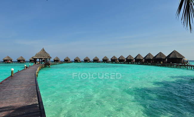 Vista panorámica del embarcadero de madera con chozas, isla de Maldivas - foto de stock