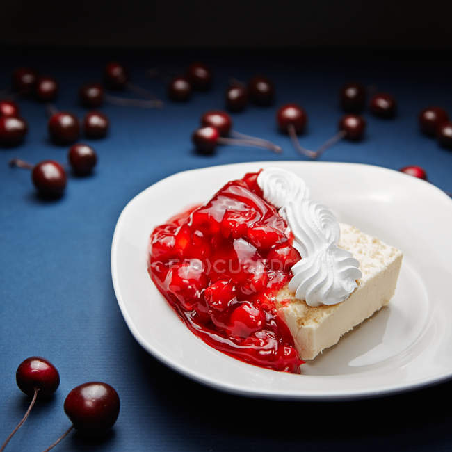 Cheesecake with cherries jam on white plate — Stock Photo