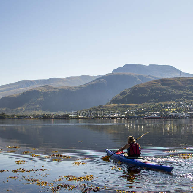 Reino Unido, Escocia, Hombre sentado en canoa en el lago - foto de stock