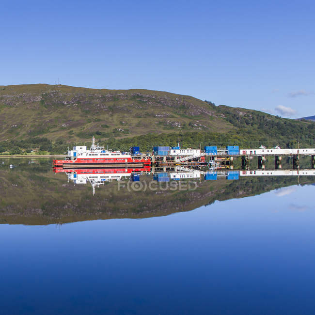 UK, Scotland, scenic view of harbor and hill reflecting in water — Stock Photo
