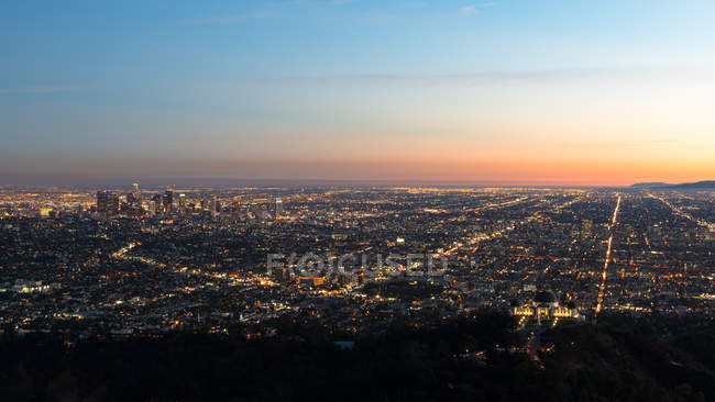 Vista panorámica del paisaje urbano iluminado al amanecer, Los Ángeles, California, EE.UU. - foto de stock