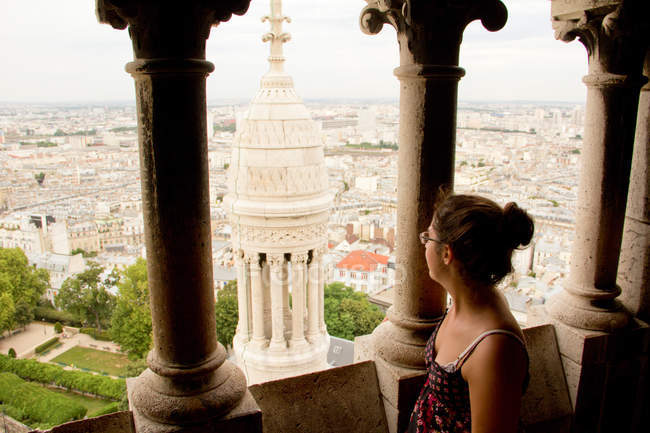Frau steht auf Brüstung und blickt auf alte historische Stadt — Stockfoto
