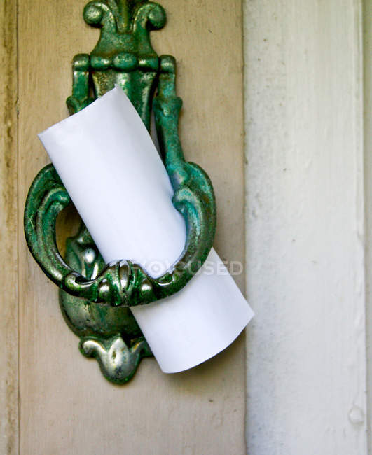 Closeup image of note left on door knocker — Stock Photo