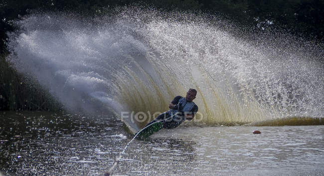 Зрілий спортивний чоловік катається на водних лижах на озері — стокове фото